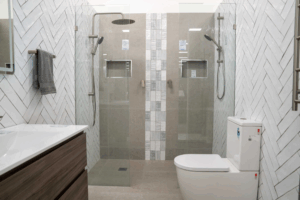 A modern bathroom display featuring dual walk-in showers and contemporary fixtures at the Jones Plumbing Plus showroom.
